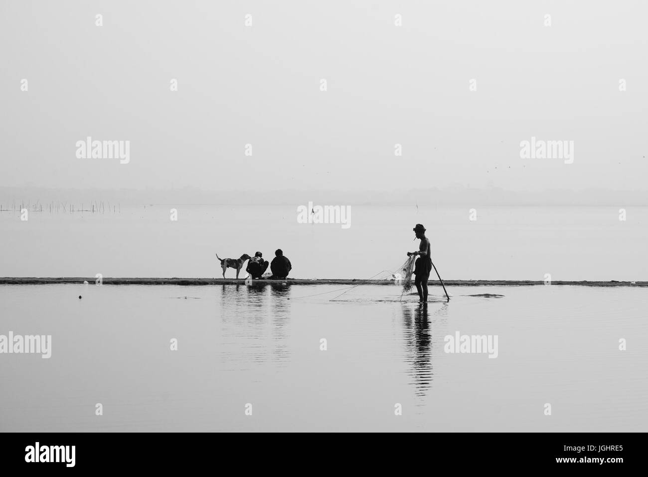 Leute fangen Fische auf dem See bei Sonnenaufgang. Schwarz und weiß. Monochrom. Stockfoto