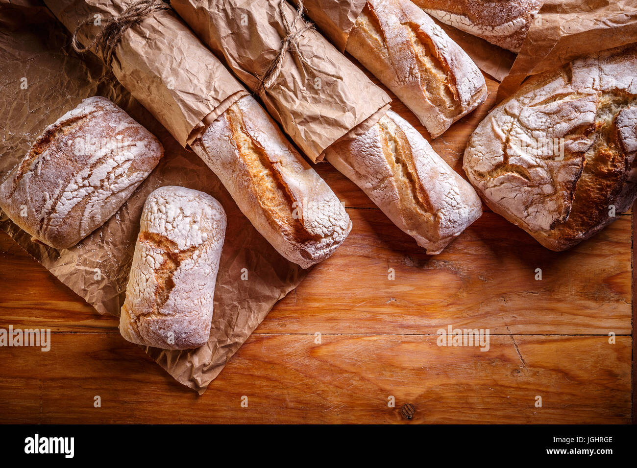 Verschiedene frische Brotsorten auf Holztisch Hintergrund Stockfoto