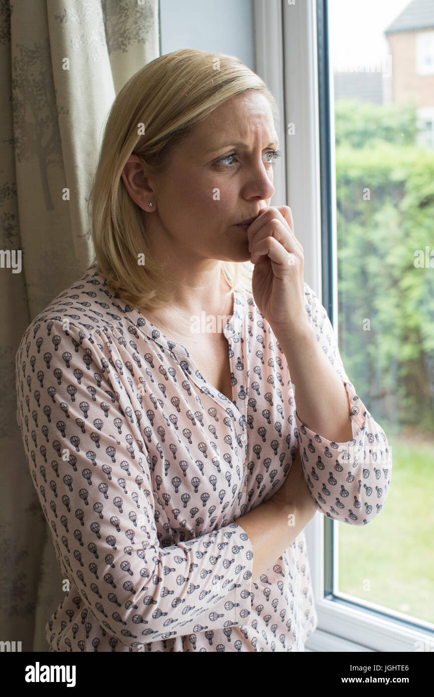 Traurige Frau leidet Agoraphobie Blick aus Fenster Stockfoto