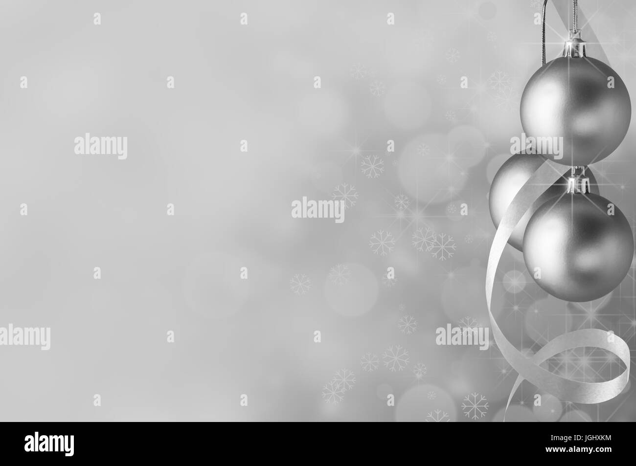 Festliche silberne Weihnachtskugeln und Spirale Streamer auf der rechten Seite. Kreise der Bokeh glühen, funkelnde Sterne und Schneeflocken in den Hintergrund verblassen towa Stockfoto