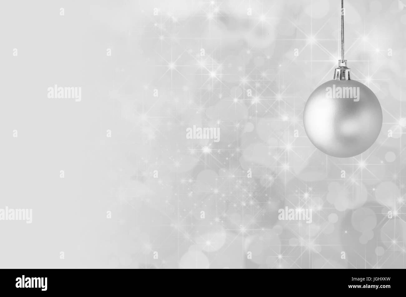 Eine silbrig graue Weihnachtskugel, ausgesetzt auf gold String Hintergrund Sterne gefüllten funkelnden Bokeh, verblassen in einfarbig, Kopie Spa bieten Stockfoto