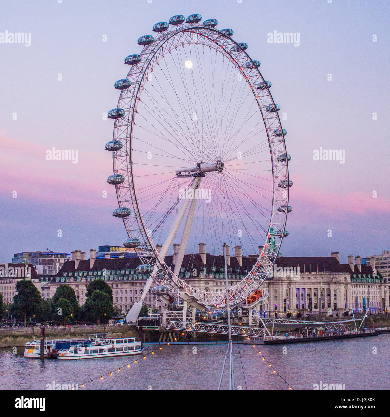 London Eye und der Mond mit County Hall dahinter, London. Stockfoto