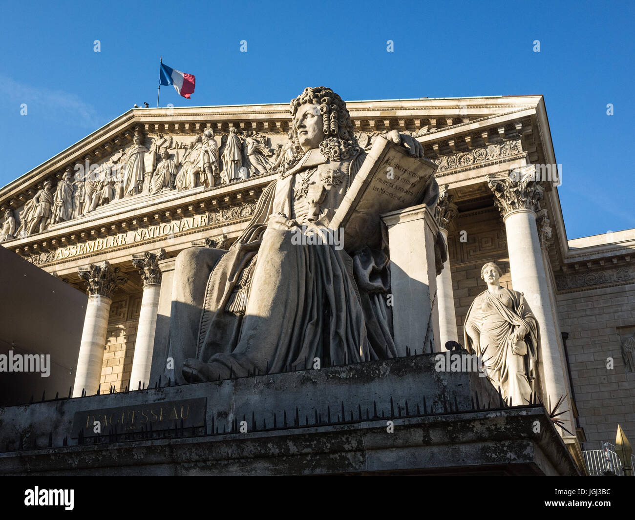 Der Palais Bourbon in Paris, dem Sitz der französischen Nationalversammlung, mit der Statue von Francois d'Aguesseau und die französische Flagge auf dem Dach. Stockfoto