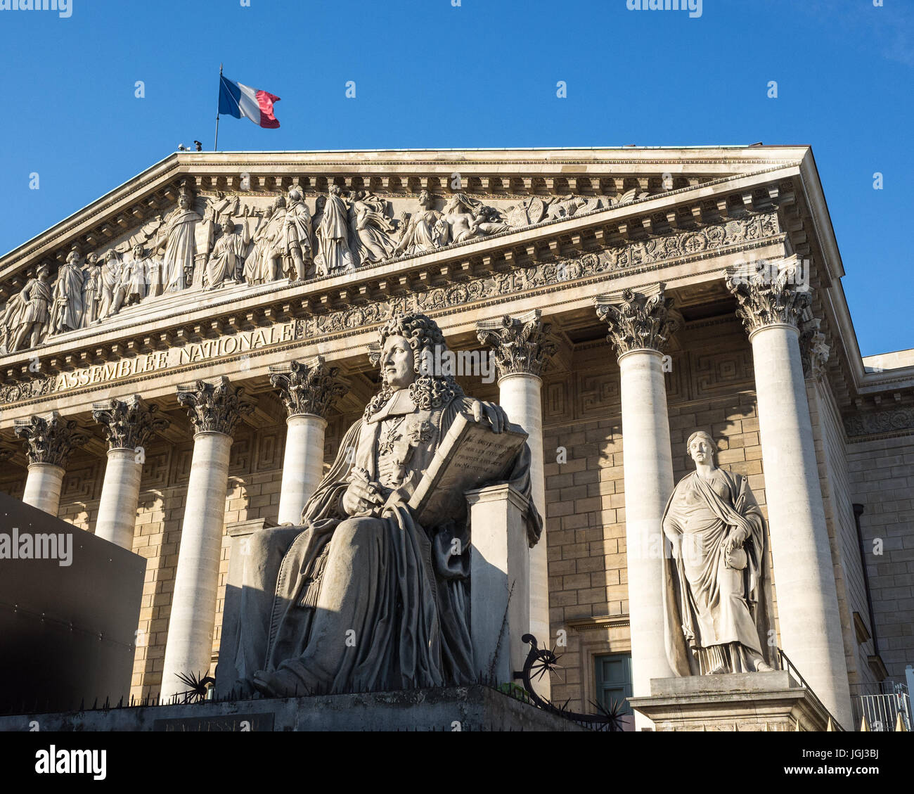 Der Palais Bourbon in Paris, dem Sitz der französischen Nationalversammlung, mit der Statue von Francois d'Aguesseau und die französische Flagge auf dem Dach. Stockfoto