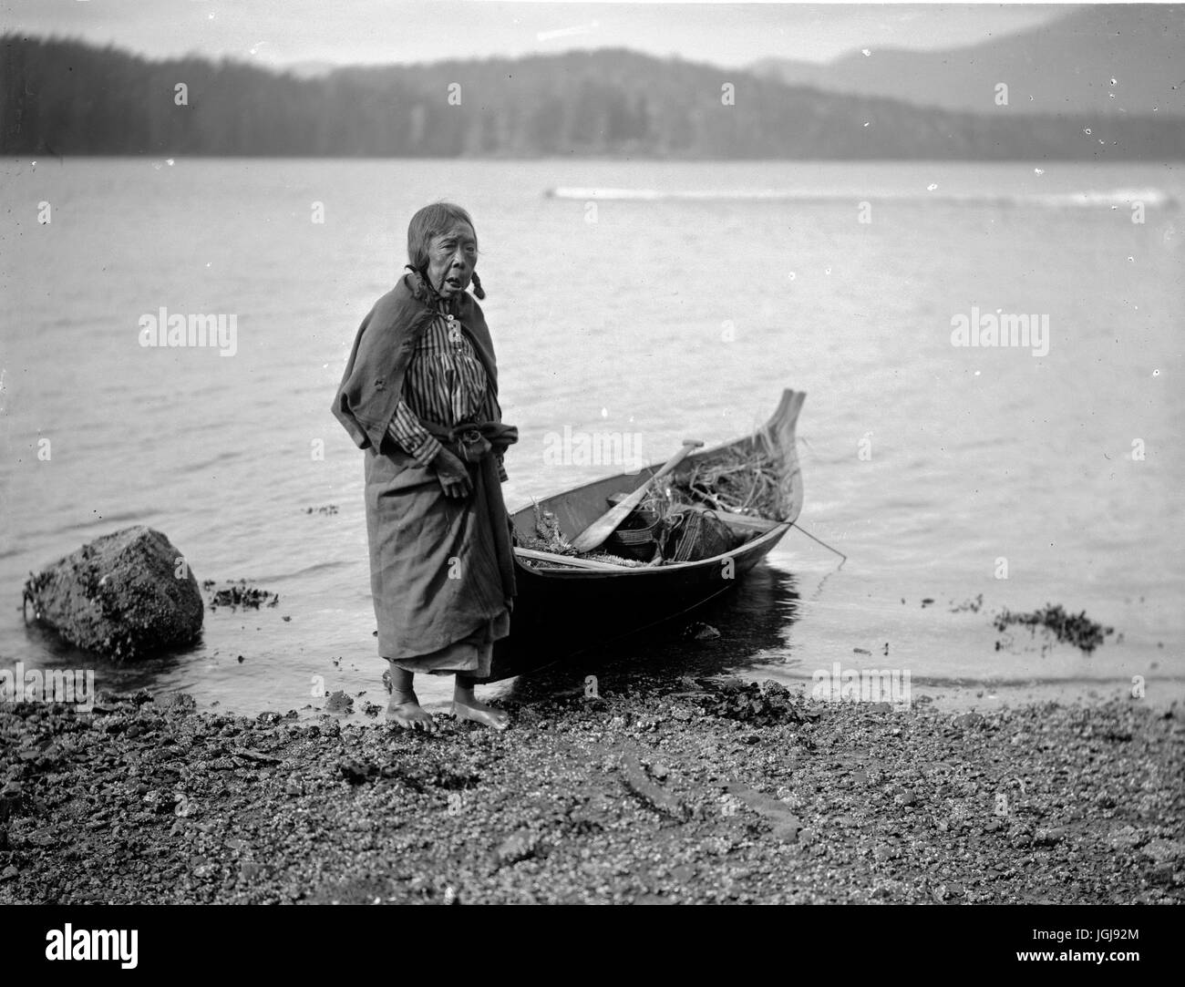 Kwakiutl Seniorin und Kanu Stockfoto