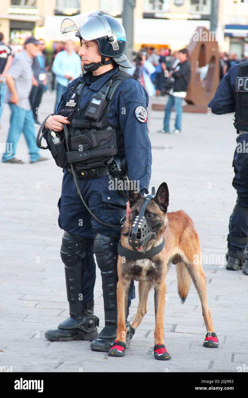 MARSEILLE, Frankreich - 21. Juni 2016: Französische Polizisten mit dem deutschen Schäferhund patrouillieren die Straße in Marseille Stockfoto