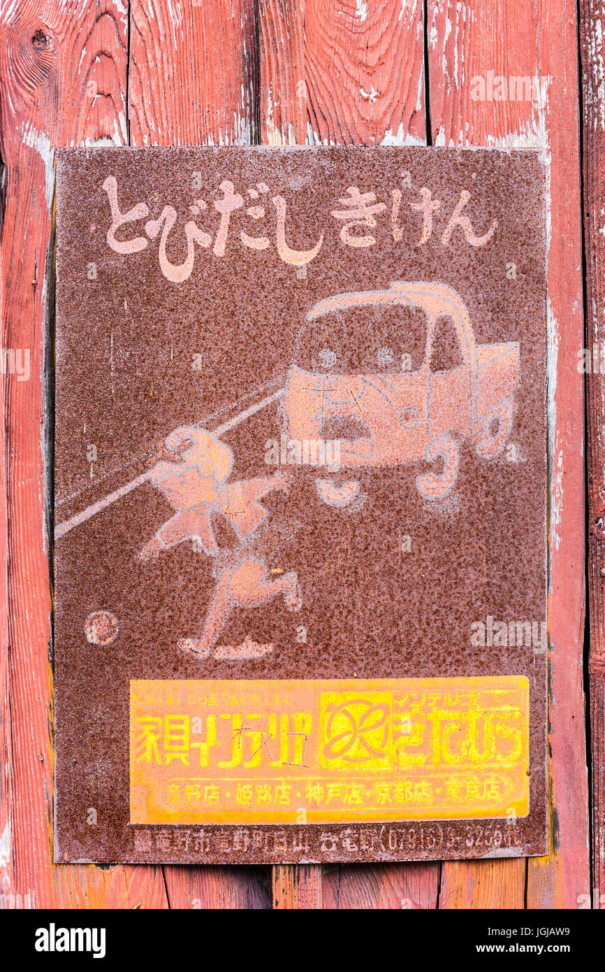 Japan, Tatsuno. Alte vintage total verrostet Japanisch Kanji Zeichen, Warnung der Kinder jagen Kugel in der Straße mit Van nach unten fahren. Stockfoto