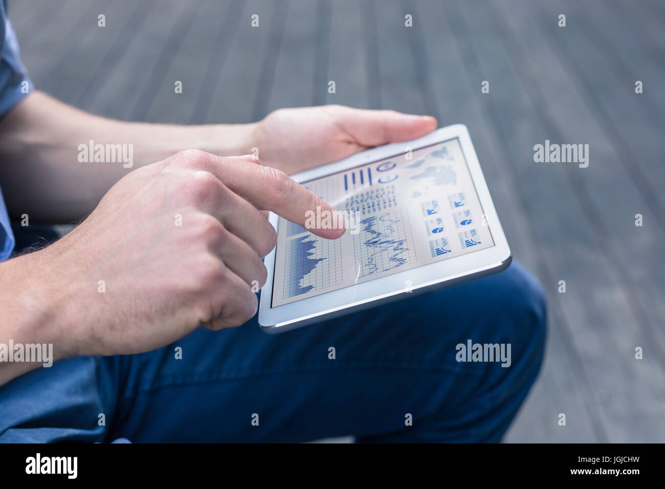 Lässige Person mit digitalen Tablet-Computer zu einem finanziellen Dashboard mit Diagrammen und Key Performance Indicators (KPI) für Börse assoz analysieren Stockfoto