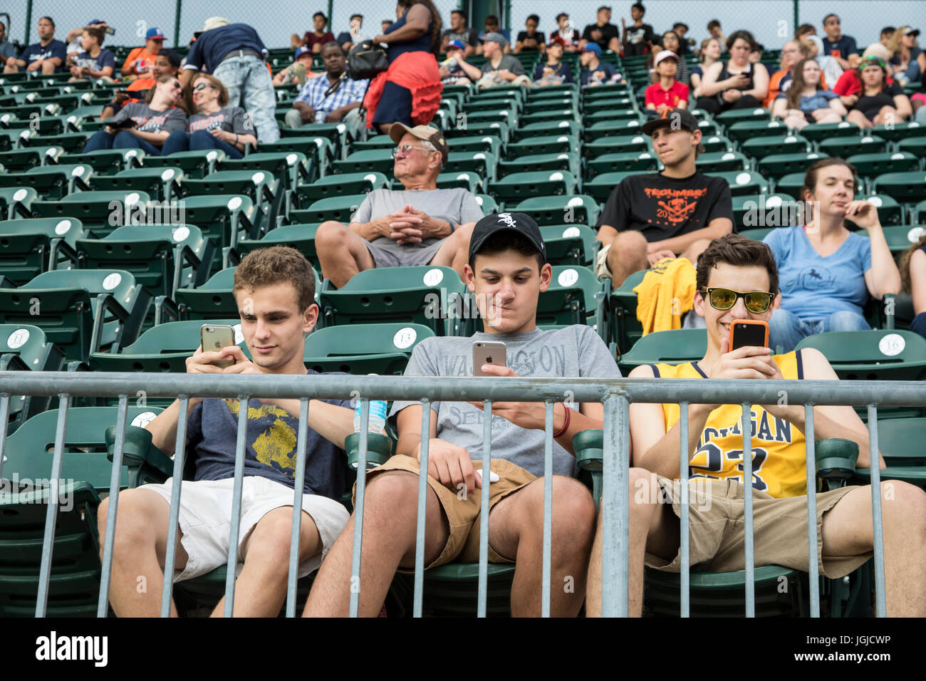 Detroit, Michigan - Jungs im Teenageralter sind geklebt, um ihre Handys während ein Baseball-Spiel der Detroit Tigers im Comerica Park. Stockfoto