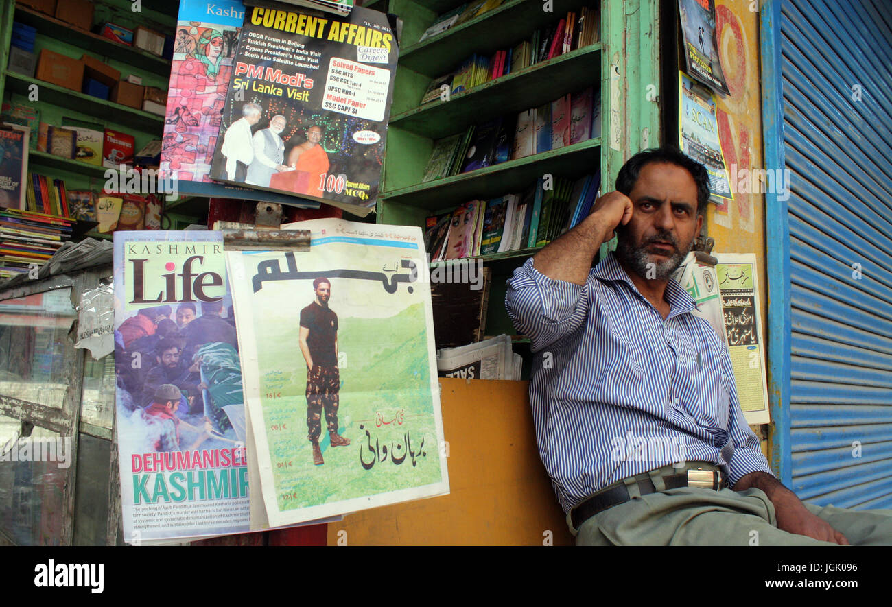 Srinagar, Kaschmir. 8. Juli 2017. Bild von Burhan Wani Szene im Nachrichten-Papier-Shop als ein Krämer spricht auf seinem Handy, während Ausgangssperre wie Restrictions.Authorities heute verhängt strenge Ausgangssperre wie Einschränkungen Kaschmir nach Recht und Ordnung als die Tal-Klammern für den ersten Todestag von Hizbul Mujahideen "Commander" Burhan Wani aufrechtzuerhalten. Bildnachweis: Sofi Suhail/Alamy Live-Nachrichten Stockfoto