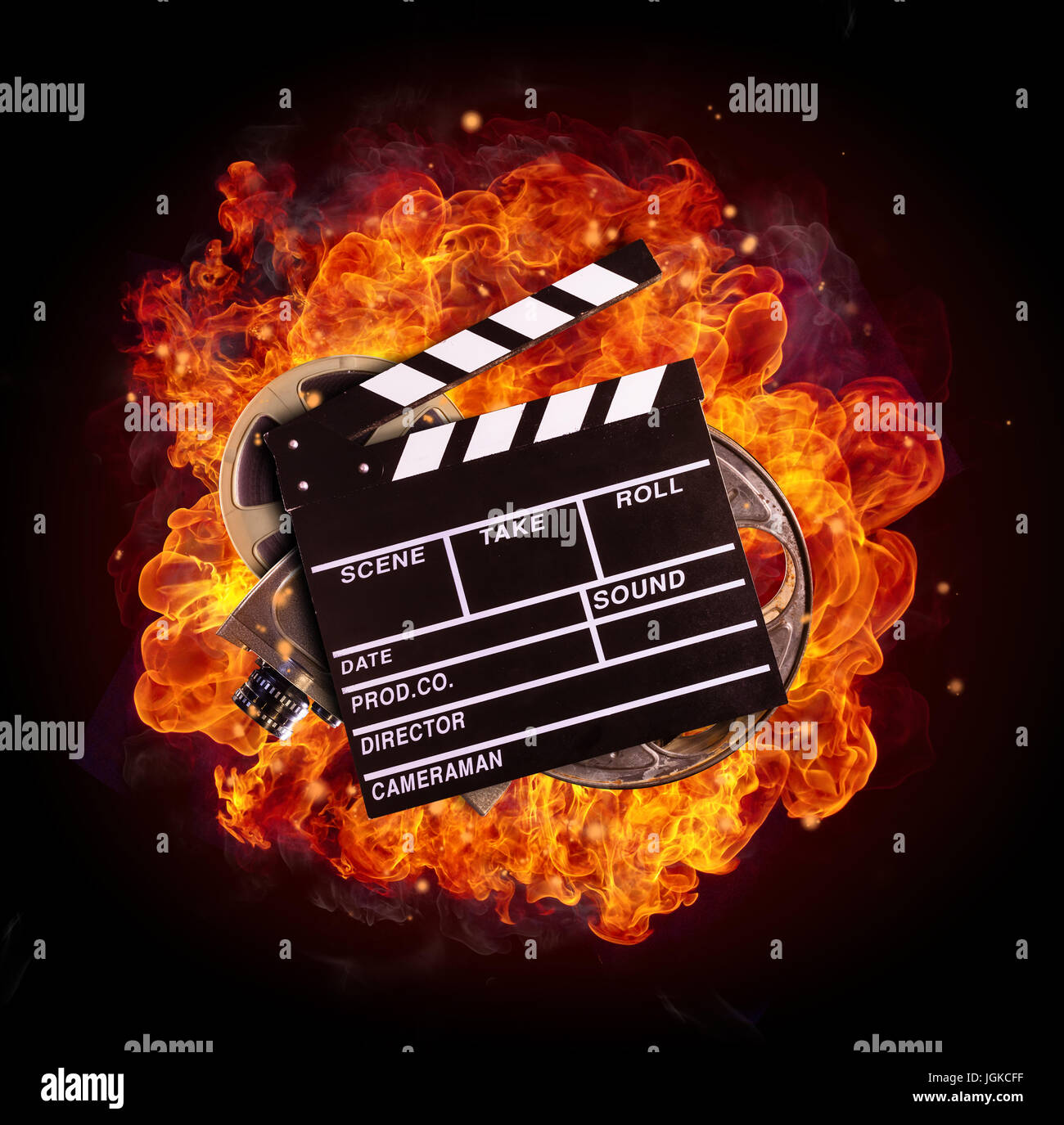 Film Klöppel, Walzen und Kamera im Feuer, auf schwarzem Hintergrund isoliert. Konzept des Filmemachens. Stockfoto