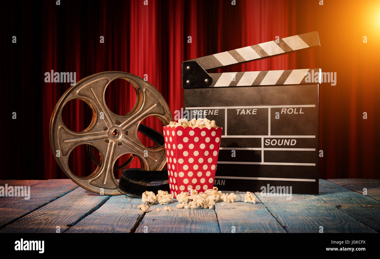 Retro-Film Produktion Zubehör auf Holzbohlen gelegt. Konzept des Filmemachens. Roter Vorhang im Hintergrund Stockfoto