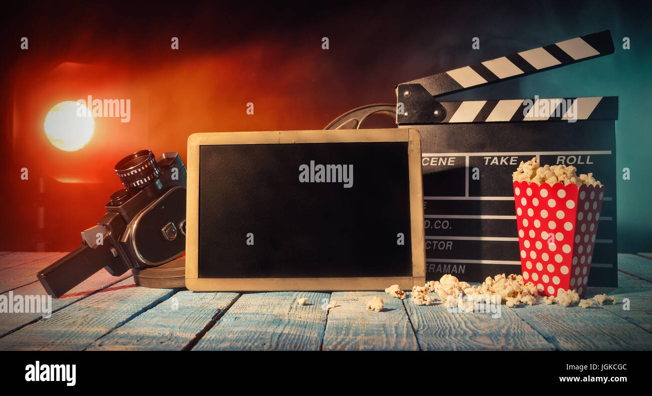 Retro-Film Produktion Zubehör platziert auf Holzbohlen mit leere Tafel für Exemplar. Konzept des Filmemachens. Effekt mit spot-Licht auf Rauchen Stockfoto