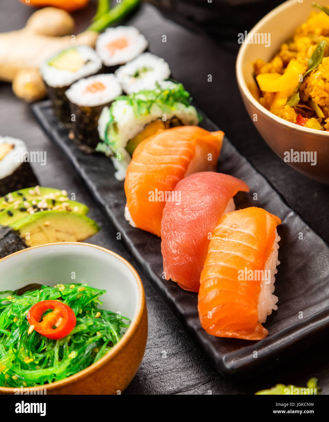 Japanische Sushi-Stücke serviert auf schwarzem Stein Stockfoto