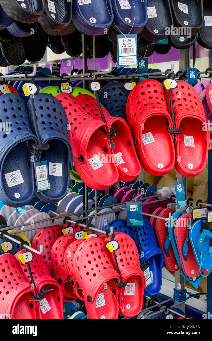 Ausstellung von Strandschuhen zum Verkauf in der Küstenstadt Newquay, Cornwall. VEREINIGTES KÖNIGREICH. Kunststoffarten. Stockfoto