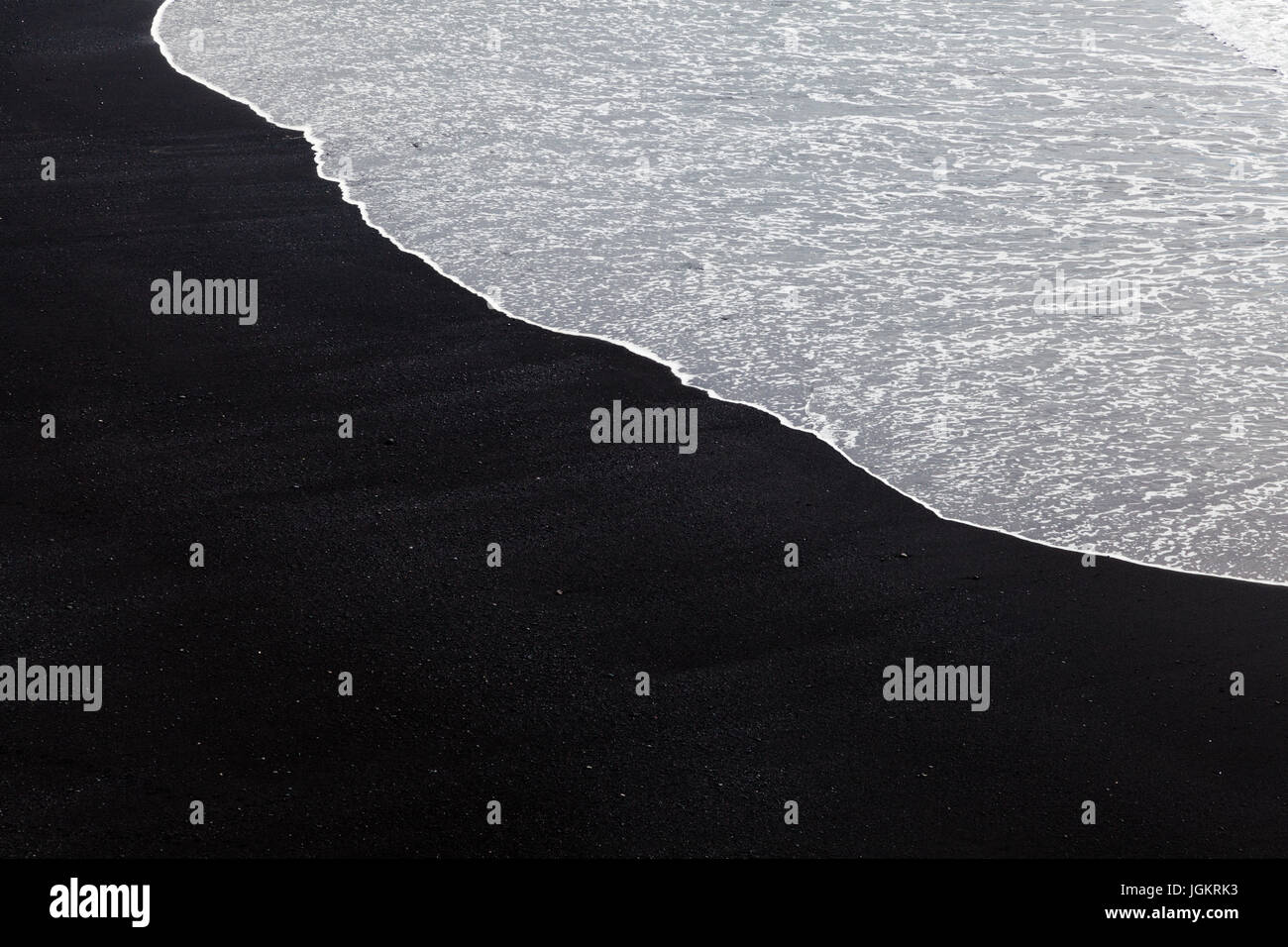 Weiße Welle Schaum abwaschen auf einem schwarzen Sandstrand in Island Stockfoto