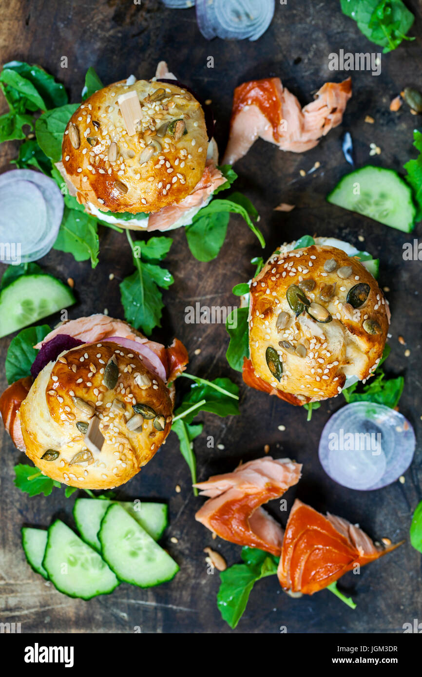 Ausgesät Brioche Brötchen mit heiß geräucherten Lachs, rote Beete und Rucola Stockfoto