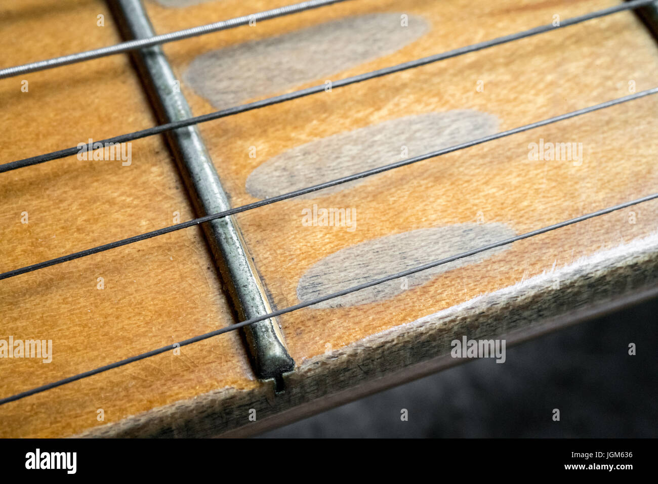 Makroaufnahme von Vintage e-Gitarre Ahornhals auf konkreten Hintergrund. Stockfoto