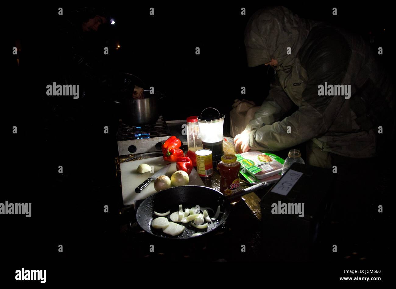 Kochen eine Mahlzeit auf einem Campingplatz in der Nacht im Regen Stockfoto