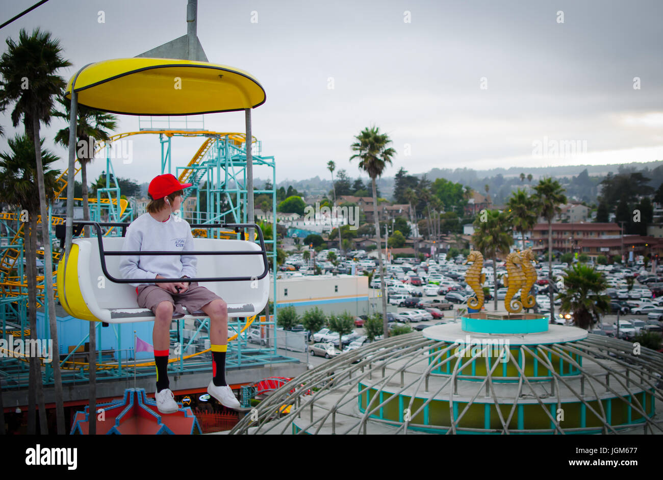 Junge sitzt in einem Wagen auf dem Santa Cruz Beach Boardwalk Skyglider Stockfoto