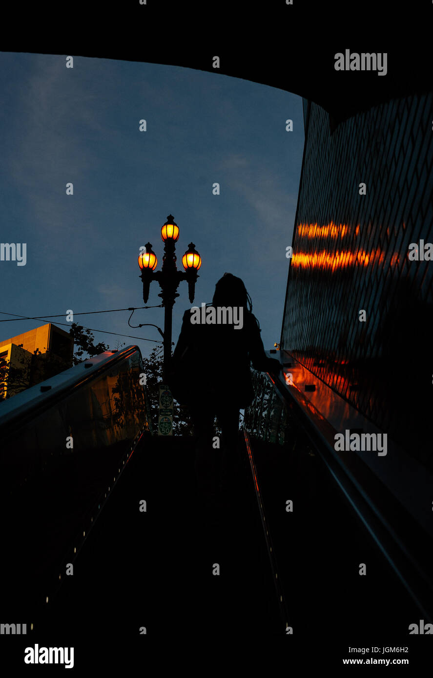 Frau, die die U-Bahn über eine Rolltreppe verlässt Stockfoto