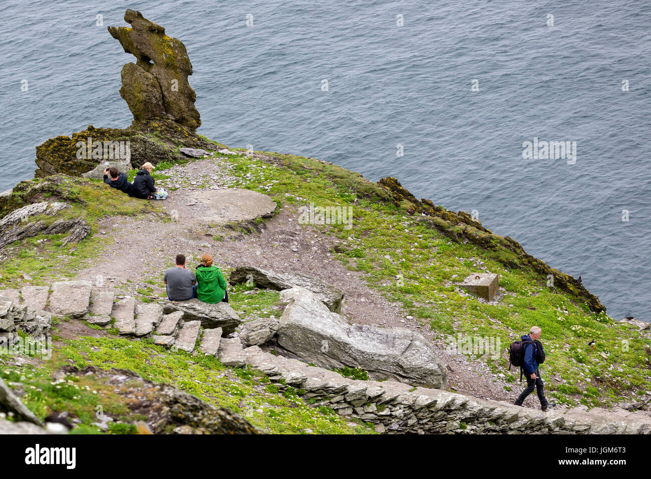 Touristen, die steinerne Treppenstufen auf Skellig Michael, County Kerry, Irland Stockfoto