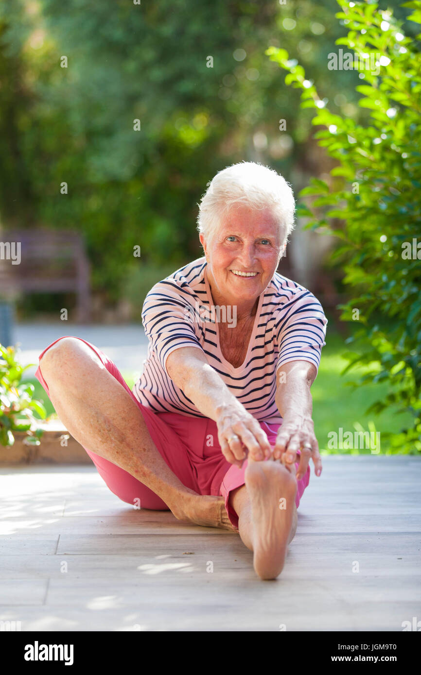 passen Sie aktive Rentner ausdehnen, rührende Zehen. Stockfoto