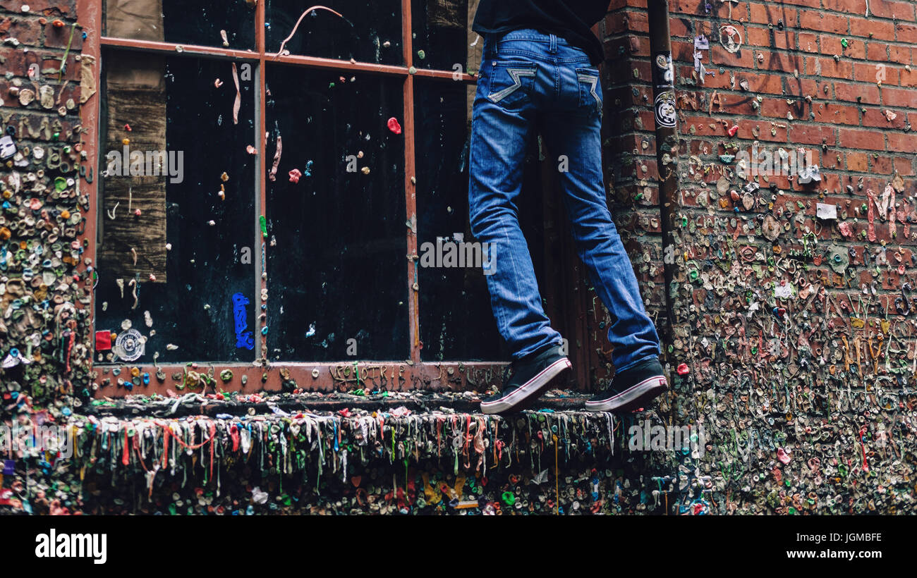 Junge klettert auf eine Fensterleiste in der Gummiwand von Seattle. Stockfoto