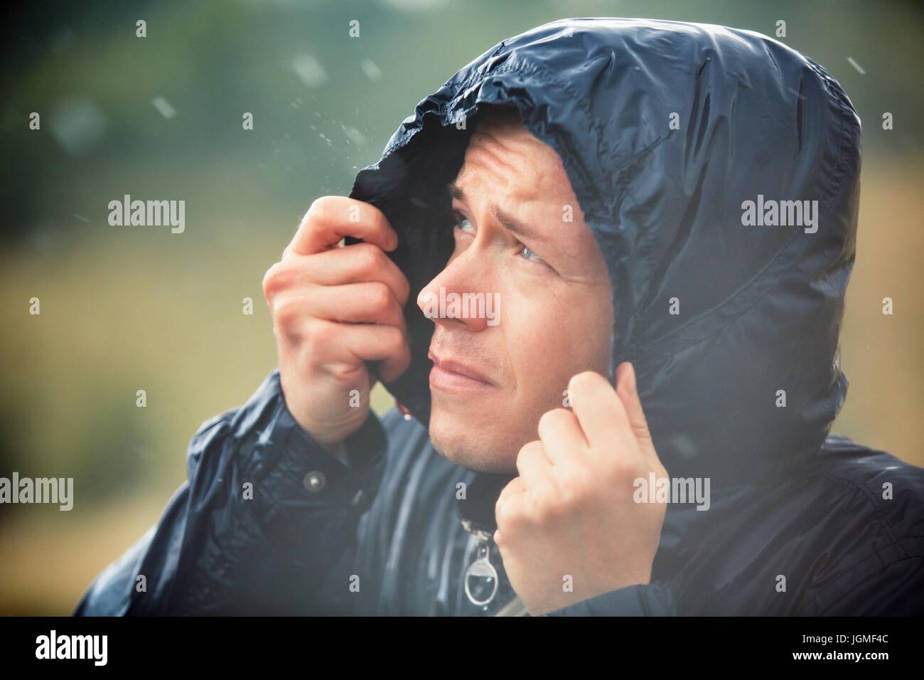 Junger Mann, Wandern in der Natur bei starkem Regen. Stockfoto