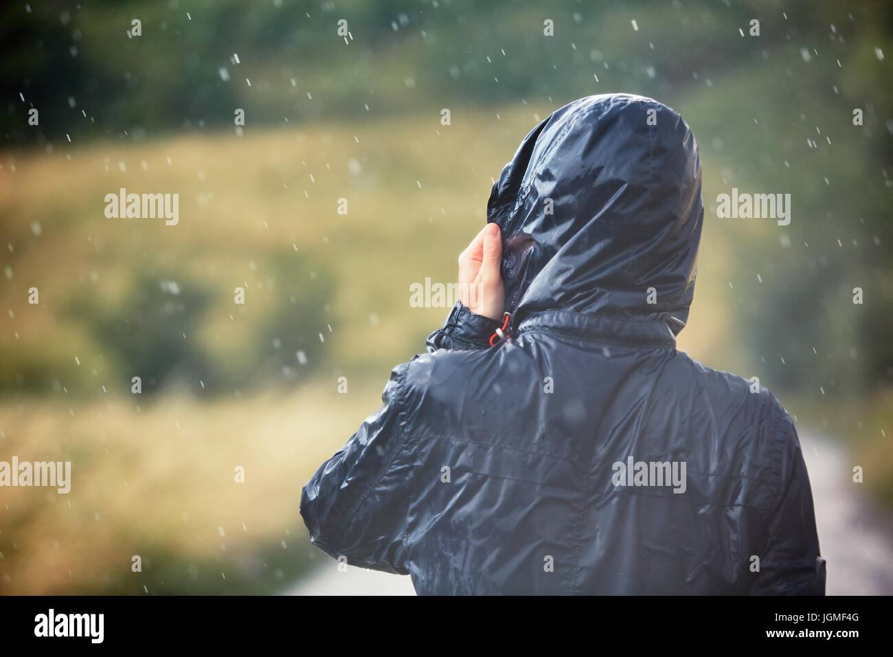 Junger Mann, Wandern in der Natur bei starkem Regen. Stockfoto