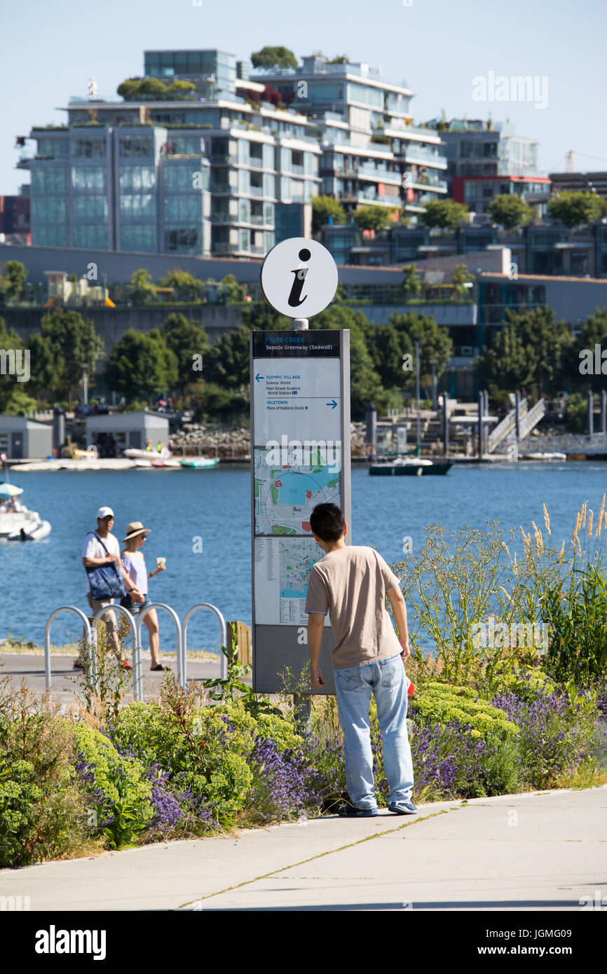 Touristen auf der Suche auf einer Karte im False Creek auf dem Meer Greenway (Deich), Vancouver, Kanada Stockfoto