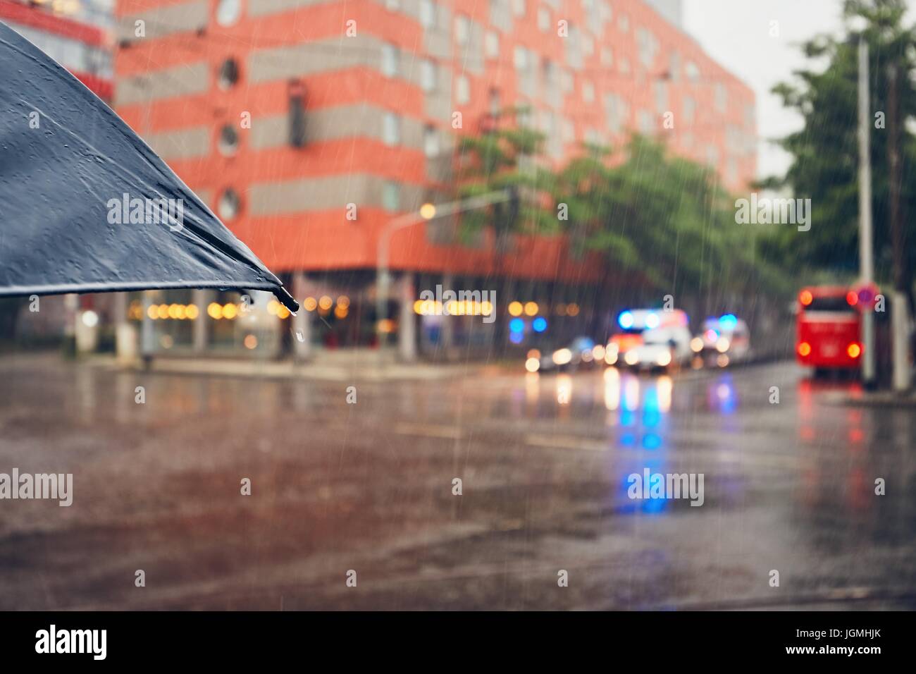 Düsterer Tag in der Stadt. Amabulances Emergency Medical Service auf der Straße bei starkem Regen. Selektiver Fokus auf dem Dach. Prag, Tschechische Republik. Stockfoto