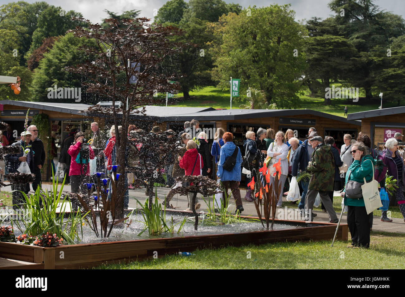 Viele Leute gehen Messestände & Ausstellung von Kupfer Wasser Originalskulpturen & Gartenfiguren - RHS Chatsworth Flower Show, Derbyshire, England, UK. Stockfoto