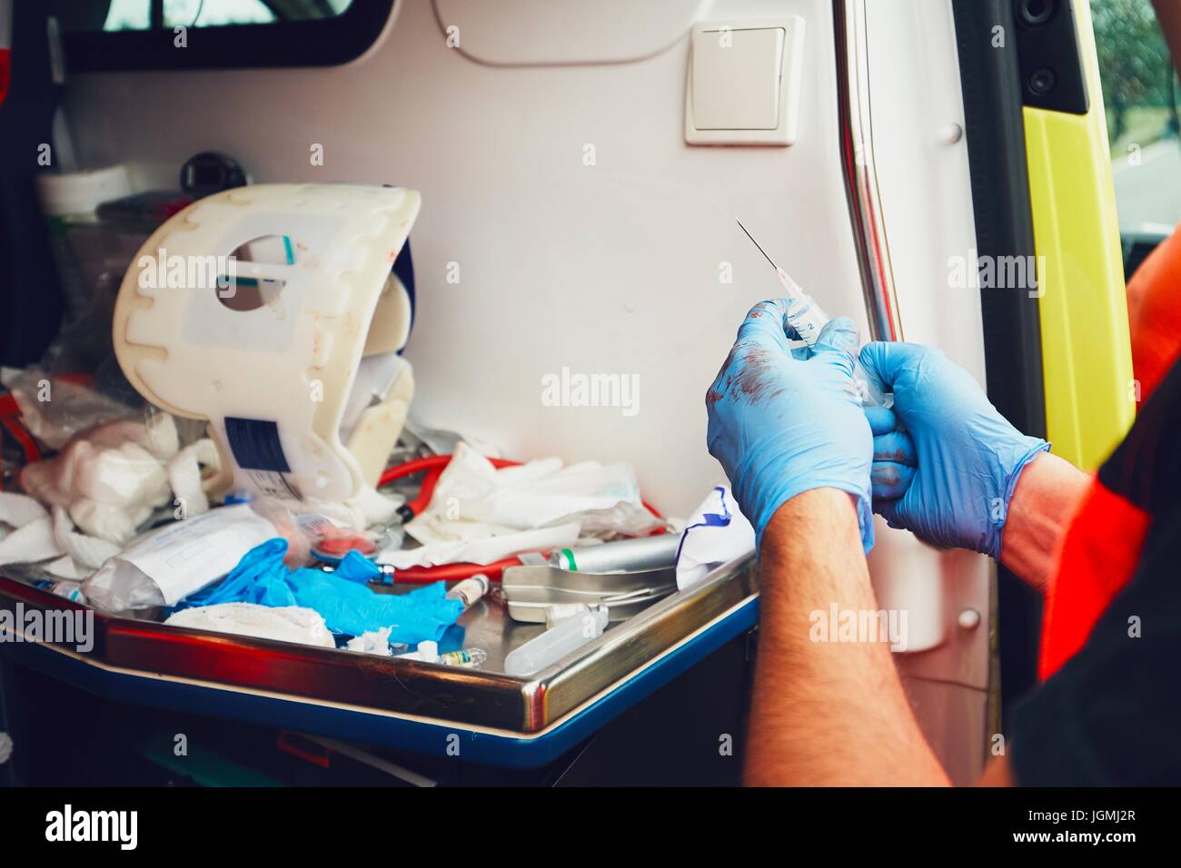 Rettungssanitäter in den Krankenwagen Tür bereitet Arzneimittel für einen verletzten Patienten (Detail der Hände). Thema der Rettung, Hilfe und Hoffnung. Stockfoto