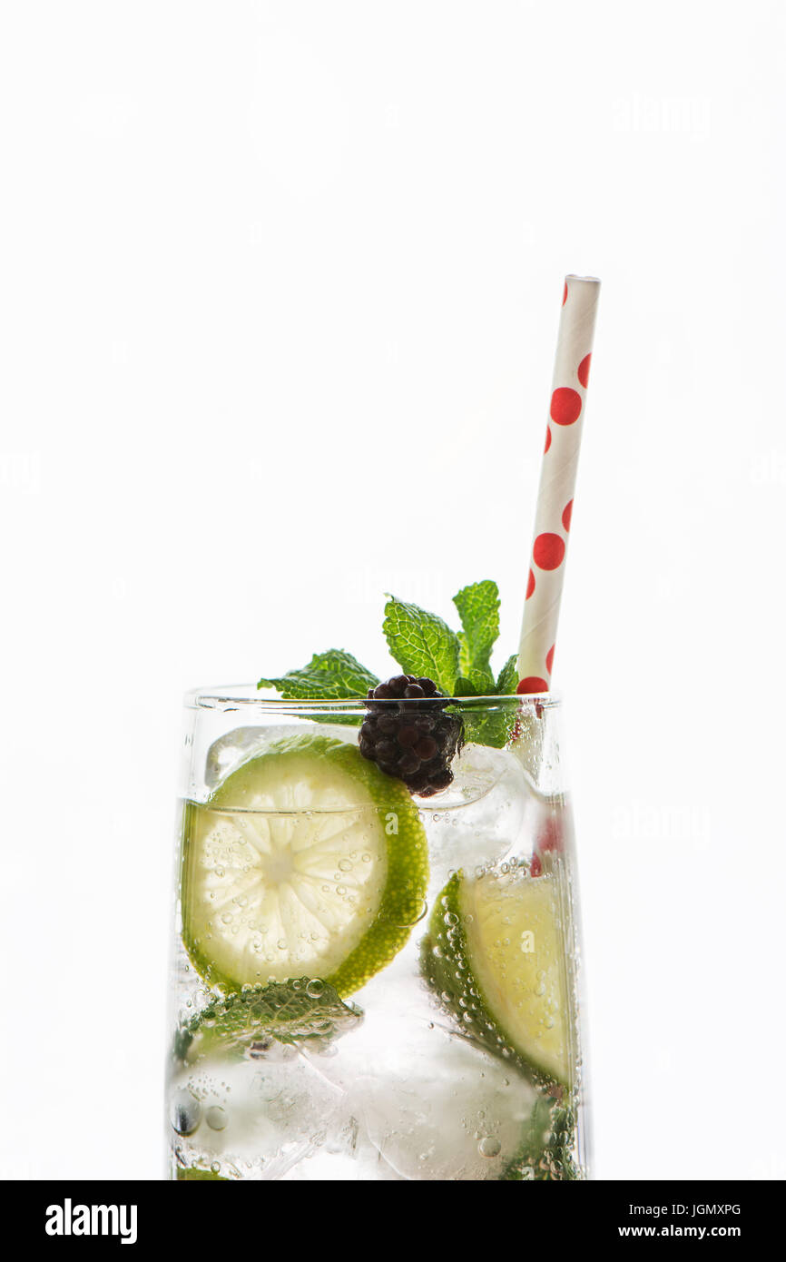 Gin Tonic cocktail mit Limetten, Eis und roten Früchten, Detail, auf weißem Hintergrund Stockfoto