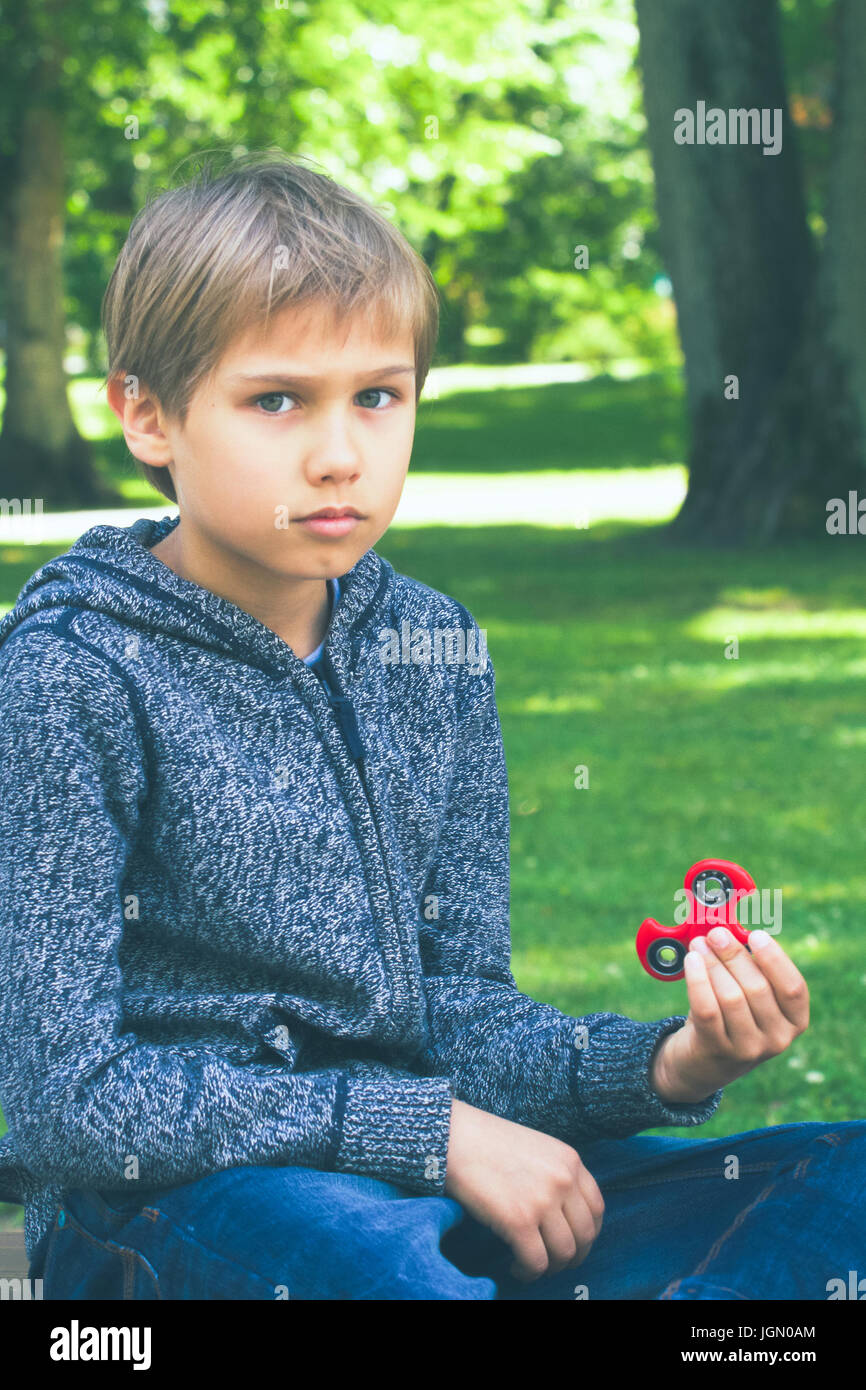 Junge mit einem Fidget Spinner im freien Stockfoto