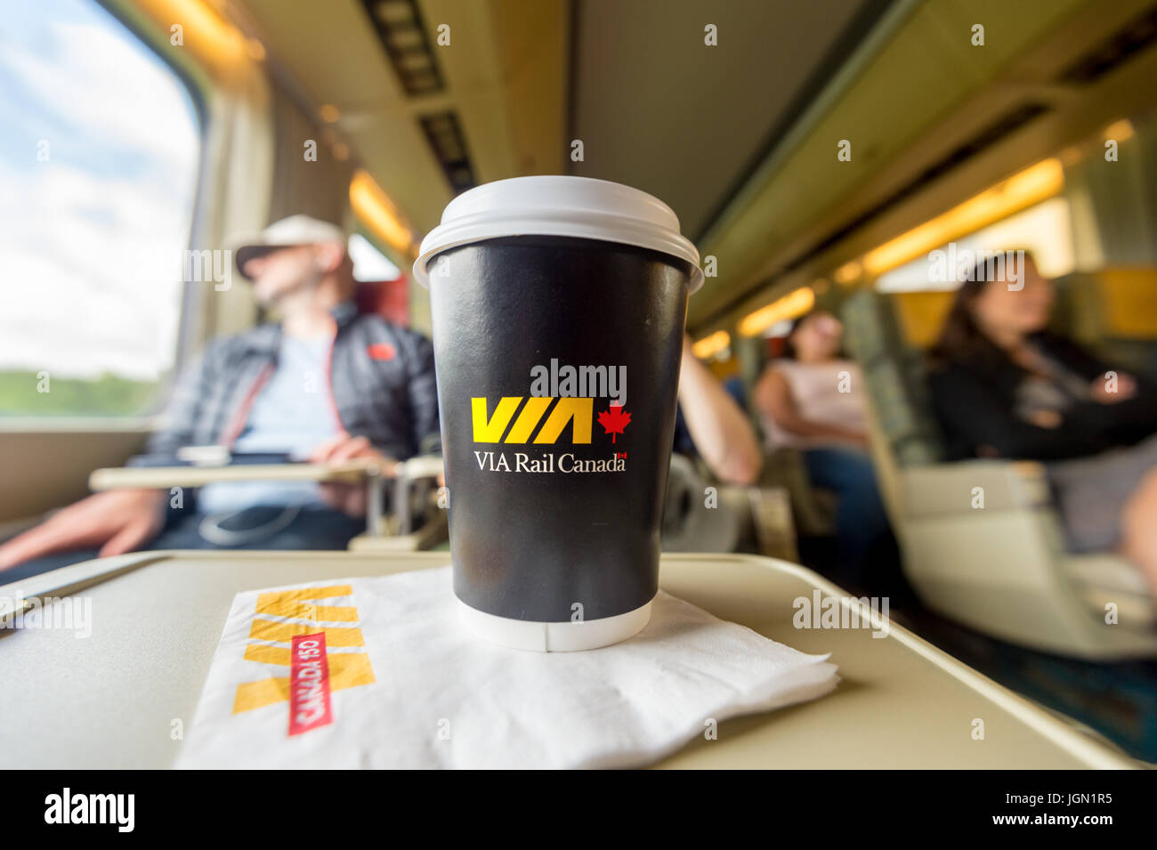 Innenraum der Triebwagen in einem ViaRail Zug auf dem Weg nach Toronto mit einer Via Rail Papier Kaffeetasse im Vordergrund Stockfoto