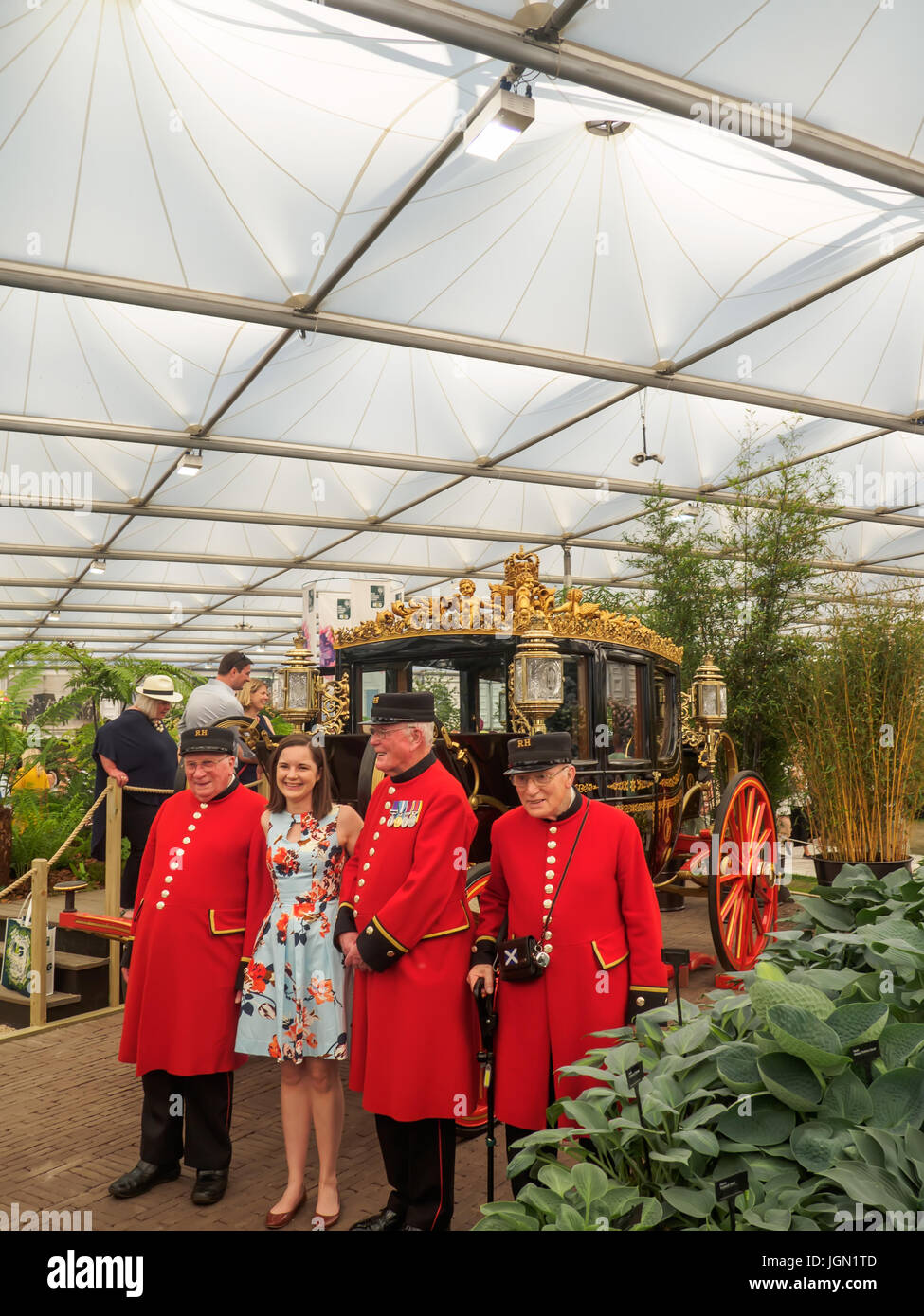 LONDON, UK - 25. Mai 2017: RHS Chelsea Flower Show 2017. Chelsea Rentner posieren mit einer jungen Frau Besucher in der Nähe der australischen State Coach. Stockfoto