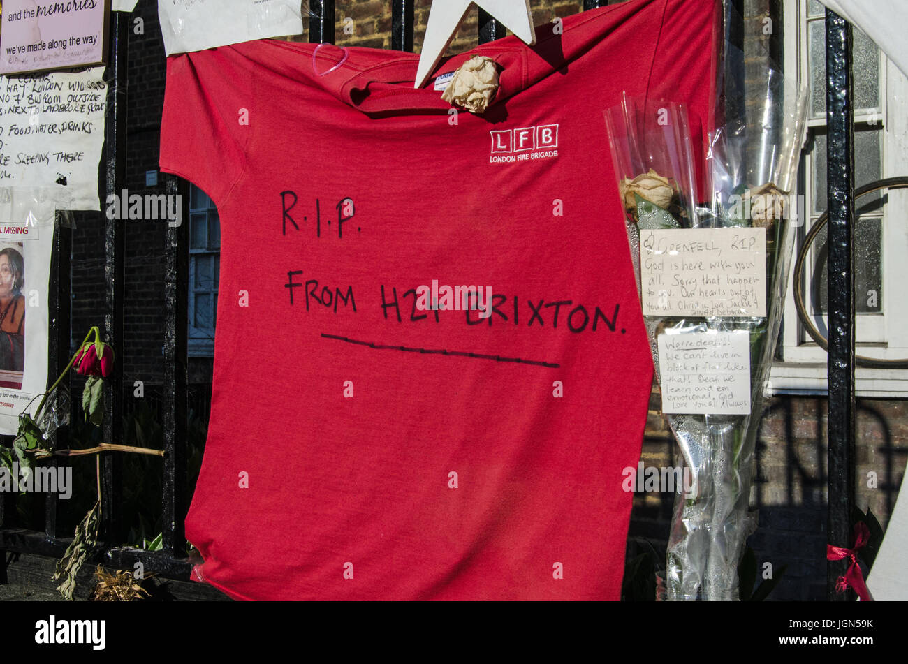 LONDON, UK - 5. Juli 2017: Gedenkstätten für die Opfer des Turmes Grenfell Feuer Disasterin Kensington, London.  Zwischen den Blumen und Nachrichten ist ein T-shirt Stockfoto