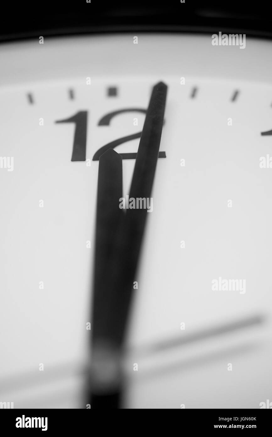 Nahaufnahme und selektiv auf die Zeiger einer Uhr eine Minute nach Mitternacht - schwarz / weiß Darstellung markieren. Der Schwerpunkt liegt auf der Zahl zwölf ein Stockfoto