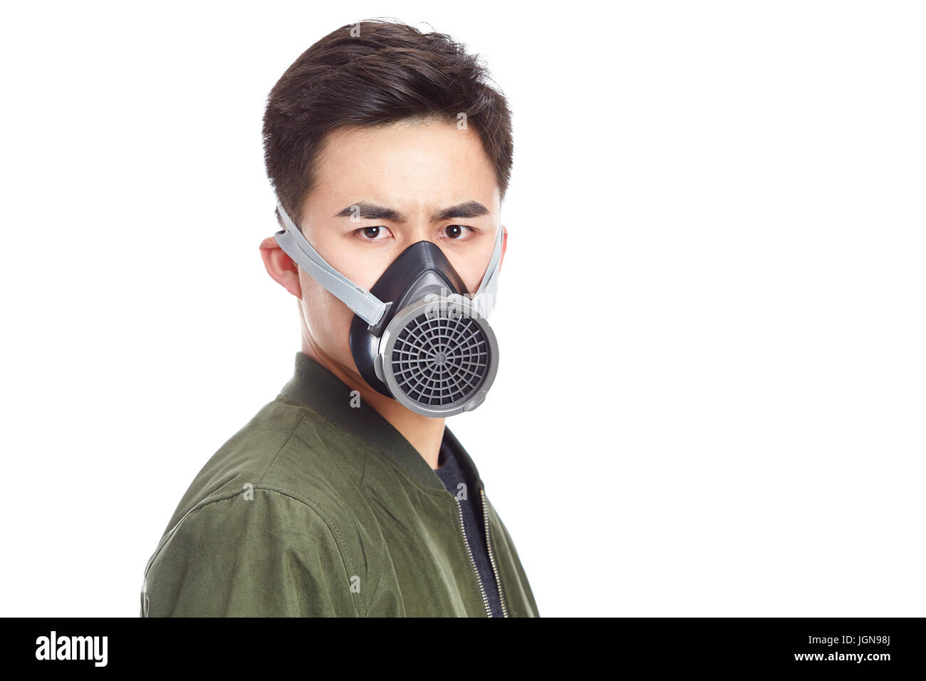 junge asiatische Mann mit Gasmaske starrte in die Kamera, isoliert auf weißem Hintergrund. Stockfoto