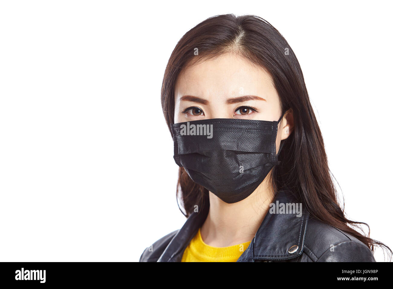 junge asiatische Frau trägt schwarzen Maske, starrte in die Kamera, isoliert auf weißem Hintergrund. Stockfoto