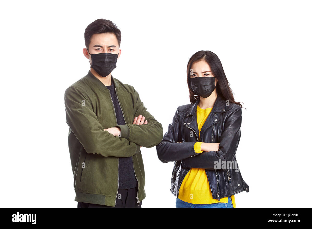junge asiatische paar tragen schwarzen Maske in die Kamera starrt, Arme gekreuzt, isolierten auf weißen Hintergrund. Stockfoto