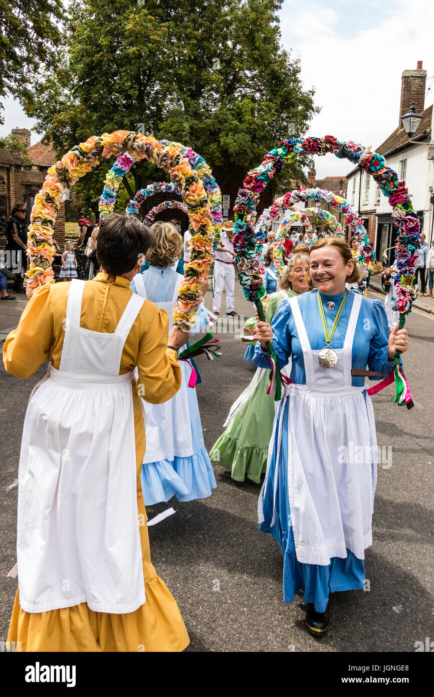 Englisch folkloristische Tänzer, Frauen aus den Knoten kann Morris Seite, Tanzen auf der Straße halten Halbkreis Girlanden aus Blumen über die Köpfe. Stockfoto