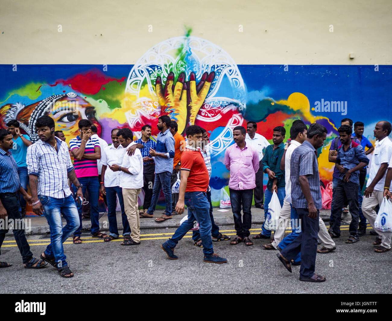 9. Juli 2017 - Singapur, Singapur - Gastarbeiter aus dem indischen Subkontinent vor ein Wandbild in Singapur. Es gibt Hunderttausende Gastarbeiter aus dem indischen Subkontinent in Singapur. Die meisten arbeiten 5 ½ sechs Tage pro Woche. Am Sonntag kommen den normalen Tag, sie in Singapurs '' Little India'' Nachbarschaft zum Essen, trinken, Geld nach Hause schicken, gehen Sie zu Ärzten und Zahnärzten und Kontakte zu knüpfen. Die meisten Beschäftigten Leben im Wohnheim Stil Gehäuse weit von Singapur und Sonntag ist der einzige Tag haben sie weg von ihren Baustellen. Die meisten Arbeiten in blauen Kragen Felder wie PHAs Stockfoto