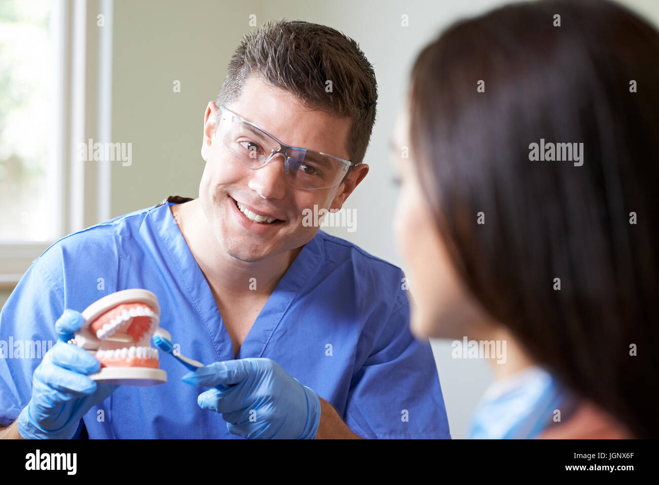 Zahnarzt, die korrekte Verwendung der Zahnbürste, weiblichen Kunden zu beweisen Stockfoto