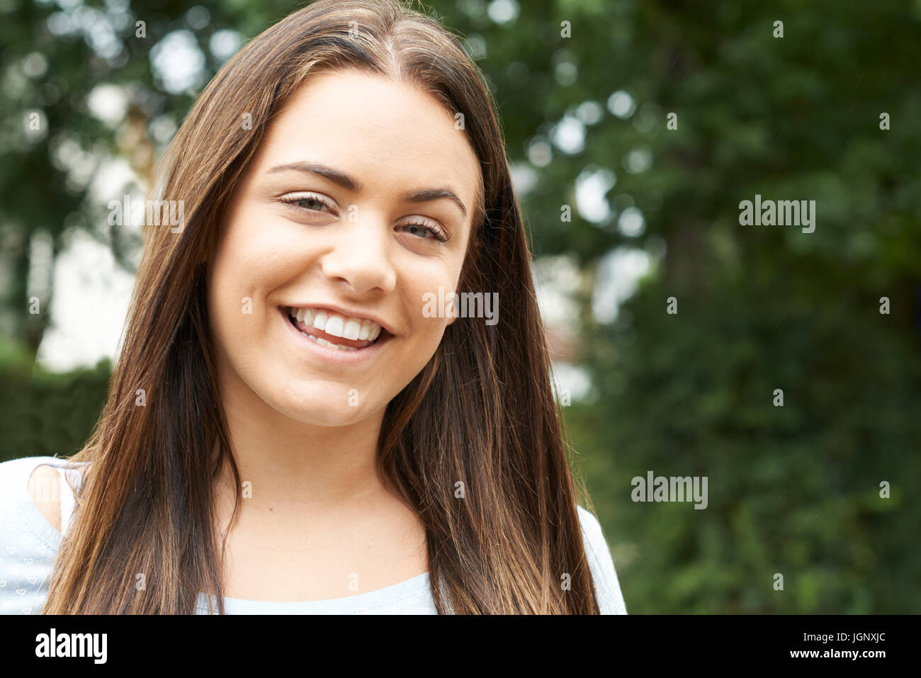 Im freien Kopf und Schultern Portrait Of Smiling Teenager-Mädchen Stockfoto