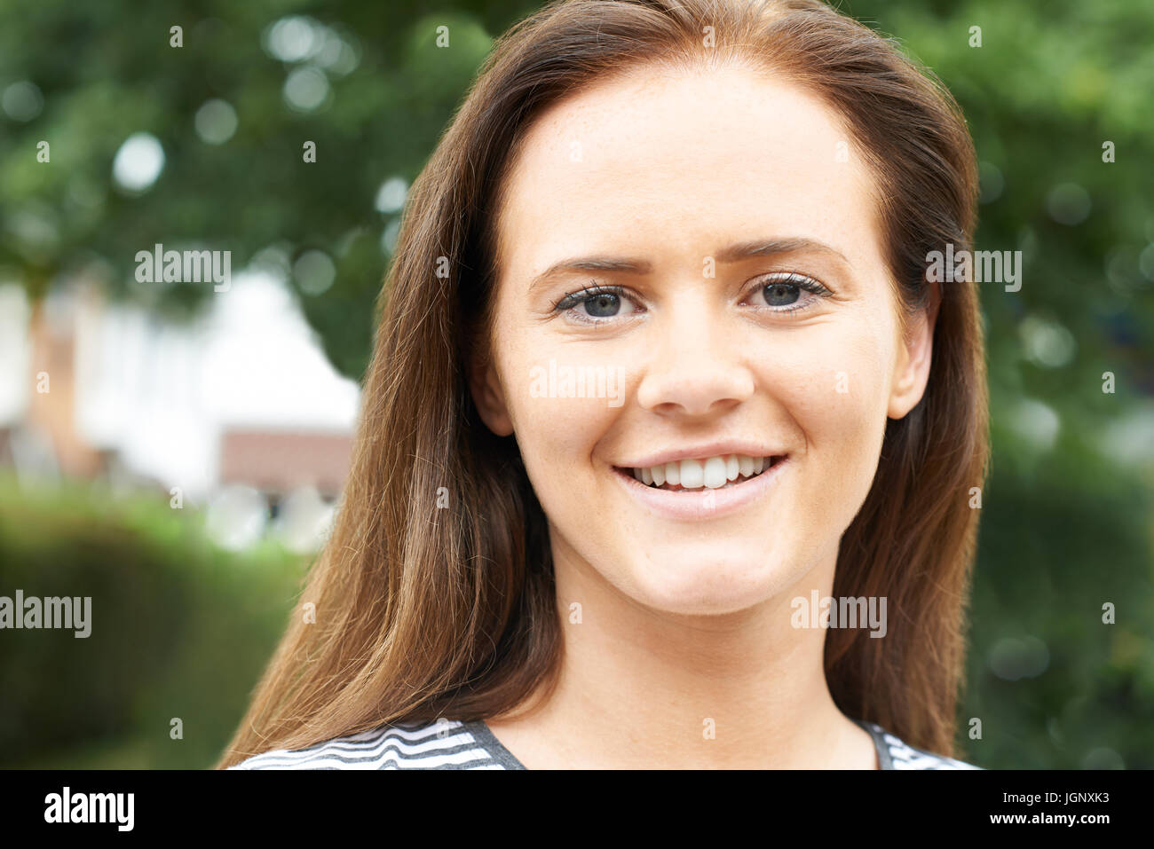 Im freien Kopf und Schultern Portrait Of Smiling Teenager-Mädchen Stockfoto