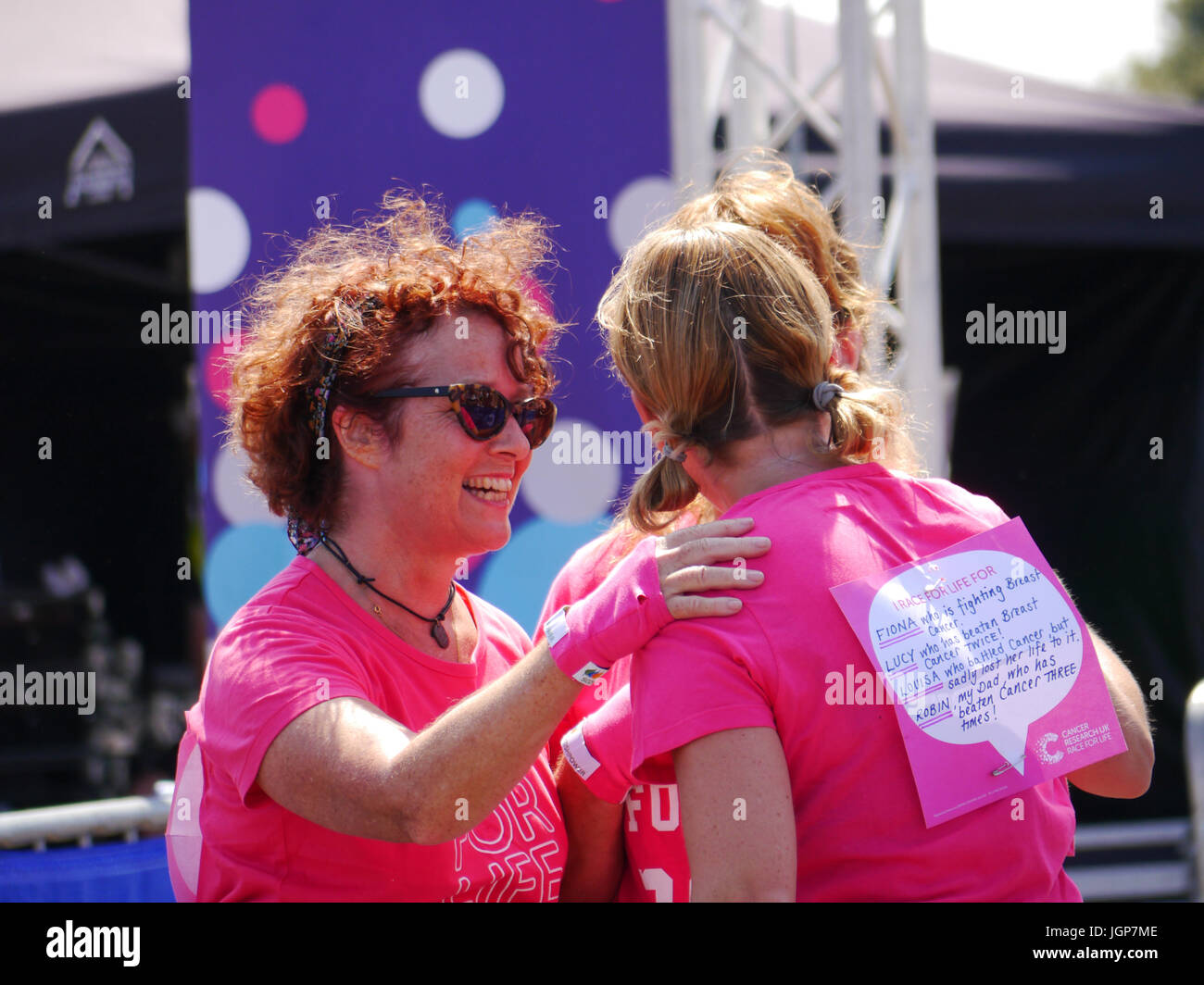 Drei Damen gratulieren einander am Ende der Race For Life Charity Rennen Stockfoto