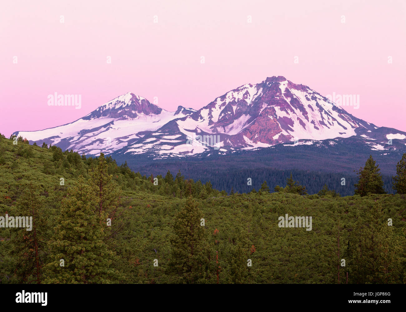 USA, Oregon, Deschutes National Forest, rosa Himmel bei Sonnenaufgang Himmel nahen Schwester (links) und North Schwester (rechts) in der drei-Schwestern-Wildnis. Stockfoto